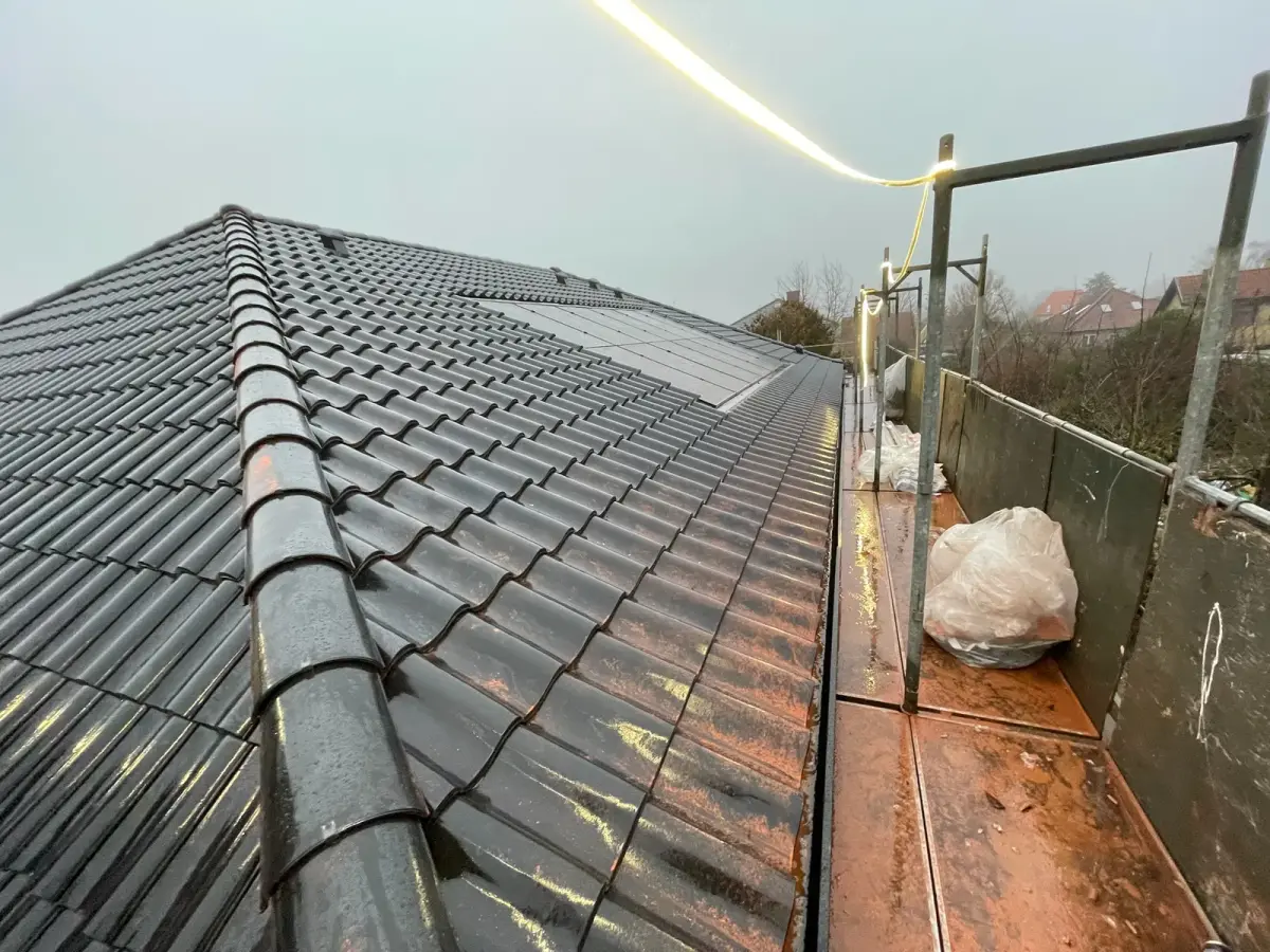 Tag under tagarbejde med opstillet stillads og afdækning omkring huset