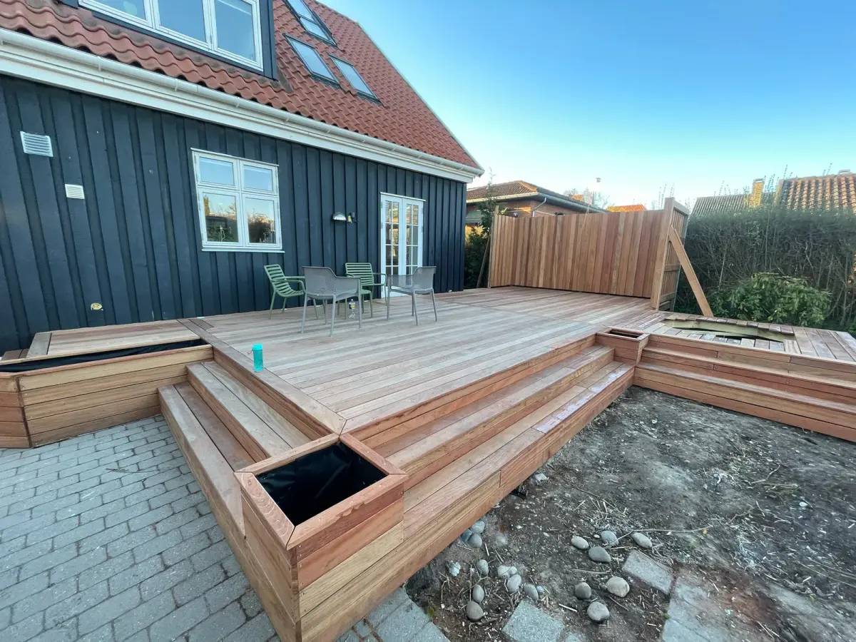 Træterrasse med indbyggede bænke bygget direkte ind i konstruktionen
